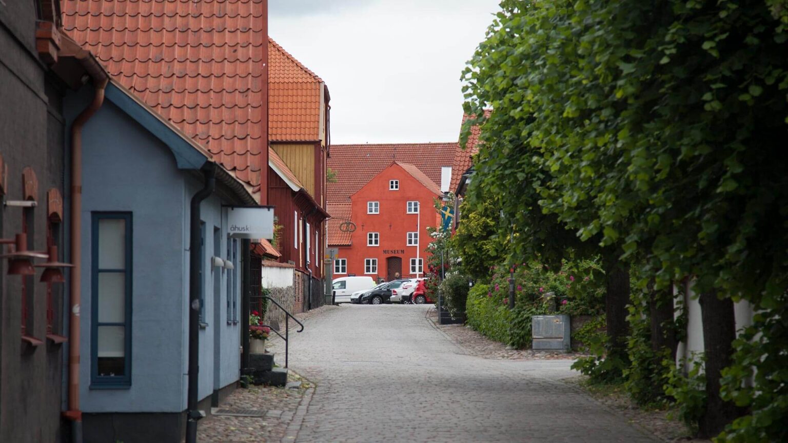 I bakgrunden syns ett rött putsat hus, Åhus museum