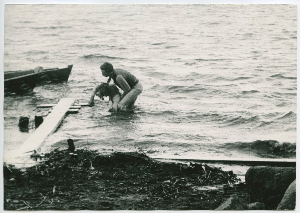 En person hjälper en annan upp ur vattnet, från filmen Värmlänningarne från 1910.