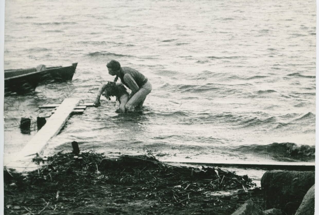 En person hjälper en annan upp ur vattnet, från filmen Värmlänningarne från 1910.