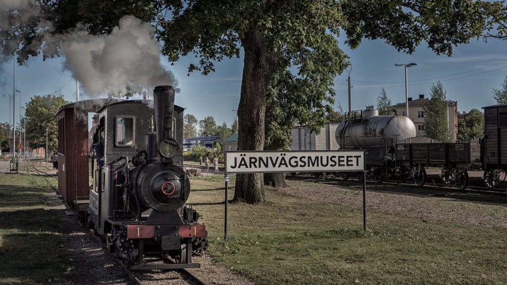Ett litet ånglok fram för en skylt med texten Järnvägsmuseet.